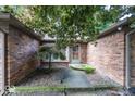 Inviting front entrance featuring a decorative tree, brick facade, and a charming covered entryway at 9133 Log Run N Dr, Indianapolis, IN 46234