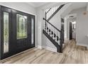 Inviting foyer features a decorative front door, staircase, and wood-look flooring at 9148 Oak Knoll Ln, Fishers, IN 46037