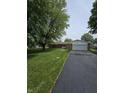 Charming single-story home with lush green lawn and mature trees at 9984 W Sunset Ln, Elwood, IN 46036