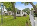 Landscaped side yard with a white picket fence surrounding a well-maintained lawn at 1116 N Berwick Ave, Indianapolis, IN 46222