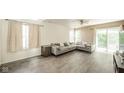 Bright living room features a large sectional, wood floors, and sliding glass doors to the exterior at 1139 Maple Stream Dr, Indianapolis, IN 46217