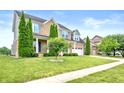 Beautiful two-story brick home with lush lawn, mature trees, and two-car garage at 1143 Hampton Dr, Greenwood, IN 46143