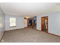 Open living area with plush carpet and stairs with open doorway to Kitchen at 1159 Oak Leaf Rd, Franklin, IN 46131