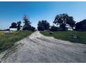 Gravel driveway leading to the home surrounded by lush grass and mature trees at 1170 E 400 S, Lebanon, IN 46052