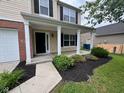 Inviting front porch with black mulch landscaping around the house's foundation at 12328 Quarry Face Ct, Fishers, IN 46037