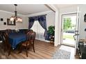Formal dining room with elegant chandelier, hardwood floors, and stylish curtains at 1744 Salina Dr, Avon, IN 46123