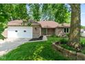 Beautiful brick home featuring a manicured lawn, mature trees, and an attached two-car garage at 180 Hollowview Dr, Noblesville, IN 46060