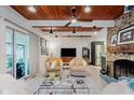 Inviting living room boasts a stone fireplace, wood ceiling, and modern decor for cozy, stylish living at 1810 S Raceway Rd, Indianapolis, IN 46231