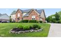 Beautifully landscaped front yard of a brick home with a well-maintained lawn at 1826 Spruce Dr, Carmel, IN 46033