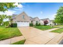 A well maintained brick home with beautiful lawn and landscaping on a sunny day at 18991 Round Lake Rd, Noblesville, IN 46060