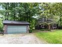 Exterior view of the home and detached garage surrounded by mature trees and a well-manicured lawn at 20417 State Road 37 N, Noblesville, IN 46060