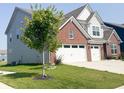 Two-story home with brick accents, light gray siding, a two-car garage, and a well-manicured front yard at 2358 S Stonehill Way, New Palestine, IN 46163