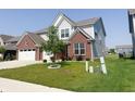 Two-story home with brick accents, light gray siding, a two-car garage, and a well-kept front yard at 2358 S Stonehill Way, New Palestine, IN 46163