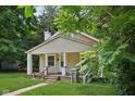 Quaint single-Gathering home with a front porch, green lawn, and a pathway leading to the entrance at 3028 Hovey St, Indianapolis, IN 46218