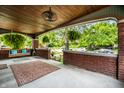 Inviting covered front porch with brick accents, hanging ferns, and porch swing at 33 N Webster Ave, Indianapolis, IN 46219