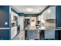 Modern kitchen with stainless steel appliances, white cabinets, and breakfast bar at 33 N Webster Ave, Indianapolis, IN 46219