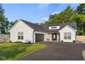 Attractive exterior shows modern farmhouse design, a black asphalt driveway, and well-manicured lawn at 3365 Riverside Dr, Columbus, IN 47203