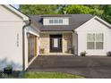 This exterior shot showcases a stone entryway, modern garage door, and beautifully landscaped surroundings at 3365 Riverside Dr, Columbus, IN 47203