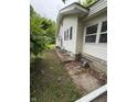 The side of the home features vinyl siding and a small walkway and is surrounded by foliage at 4931 Orion Ave, Indianapolis, IN 46201