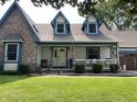 Inviting front porch with white railings, 'HOME' decor, and a patriotic American flag at 530 Denny Dr, Mooresville, IN 46158