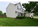 Side view of a two-story home with vinyl siding, a well-kept lawn, and landscaping at 5456 Reston Dr, Plainfield, IN 46168