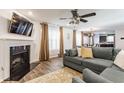 Cozy living room featuring a fireplace, a ceiling fan, and modern decor at 5794 Cherrywood Ln, McCordsville, IN 46055