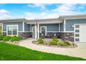 Charming front porch with cozy seating, stone accents, and walkway at 655 N Sobota Way, Trafalgar, IN 46181