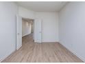 Neutral bedroom with wood-look floors, white walls, and an open doorway at 7151 Firestone Rd, Whitestown, IN 46052