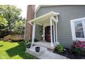 Inviting front porch and entrance to this beautiful home with brick chimney and garden at 8023 Talliho Dr, Indianapolis, IN 46256