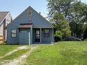 View of the back of a blue home with a small shed and green lawn at 812 N California St, Indianapolis, IN 46202