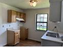 Kitchen with wooden cabinets, double stainless steel sink, and large window at 812 N California St, Indianapolis, IN 46202