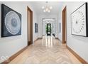 Hallway with wood floors in a herringbone pattern and modern art at 855 N East N St # 104-B, Indianapolis, IN 46202