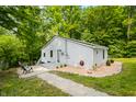 A charming home boasting light gray siding, a durable metal roof, a warm 'Welcome' sign, and surrounded by a verdant setting at 8576 Riser Dr, , IN 46164