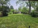 Expansive backyard with lush green lawn and mature trees, offering a serene outdoor space at 927 Cecil Ave, Indianapolis, IN 46219