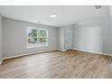 Bright, open-plan living room with wood-look flooring and a large window allowing ample natural light at 9949 Nightsong Ln, Avon, IN 46123