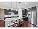 Modern kitchen with stainless steel appliances, granite countertops, dark wood cabinets and a large island with seating at 10806 Solis Cir, Fishers, IN 46038