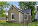 Exterior shot of the home's back, featuring a fenced backyard and mature trees providing shade at 1106 N Sheffield Ave, Indianapolis, IN 46222