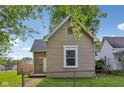 Side view of the home showcasing the architecture and landscaping, surrounded by a chain link fence at 1106 N Sheffield Ave, Indianapolis, IN 46222