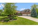 Beautiful home with lush landscaping, a pond, and an attached garage, creating a welcoming and picturesque curb appeal at 11761 Darsley Dr, Fishers, IN 46037