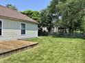 Spacious backyard featuring a wooden deck, green grass, and a classic wooden fence at 12307 Chiseled Stone Dr, Fishers, IN 46037