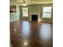 Bright living room with a fireplace, ceiling fan, wood flooring, and multiple windows providing natural light at 12307 Chiseled Stone Dr, Fishers, IN 46037