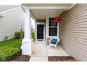 Inviting front porch with a white chair and hanging flowers, offering a cozy and charming entrance at 12820 Gloria Dr, Fishers, IN 46037