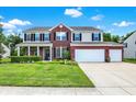 Inviting two-story home boasting a manicured lawn, three-car garage and brick and siding facade with classic shutters at 1343 Turfway Dr, Avon, IN 46123