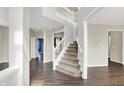 Open foyer featuring a staircase with white railings and dark wood floors throughout the main level at 1343 Turfway Dr, Avon, IN 46123