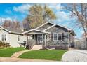 View of cozy one-story home with a front porch, neutral siding, and a well-kept lawn on a sunny day at 1409 N Chester Ave, Indianapolis, IN 46201