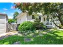 View of a well-maintained home with a charming porch and lush landscaping at 1411 N Kenmore Rd, Indianapolis, IN 46219