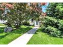 View of a cozy home with a manicured lawn, mature trees, and a welcoming walkway at 1411 N Kenmore Rd, Indianapolis, IN 46219