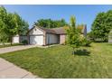 Well-maintained single-story home with an attached two-car garage, green lawn, and lovely landscaping at 1450 Millridge Dr, Greenwood, IN 46143