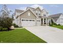 Inviting two-story home with a spacious driveway leading to a two-car garage and charming front yard at 15598 Memorial Way, Fishers, IN 46037