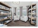 Cozy sitting room with hardwood floors, built-in shelving, comfortable chairs, and bright natural light at 15598 Memorial Way, Fishers, IN 46037